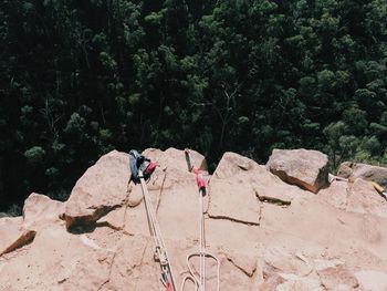Men on rock against trees