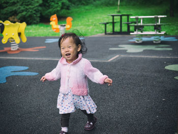 Portrait of girl playing on road