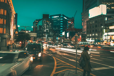 Woman using mobile phone in city at night