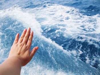 Cropped image of person hand in water