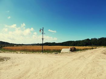 Hay bales on field against sky