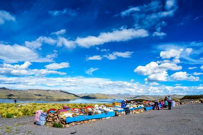 People at beach against sky