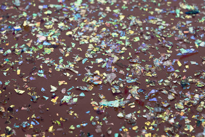 Neon pearl confetti and sparkles background. top view, flat lay. copyspace for text. 