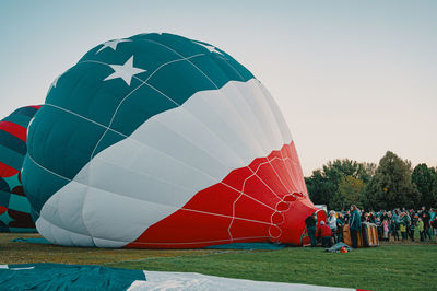 People on hot air balloon against sky