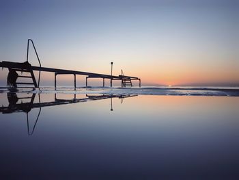 Silhouette boat on sea against clear sky during sunset