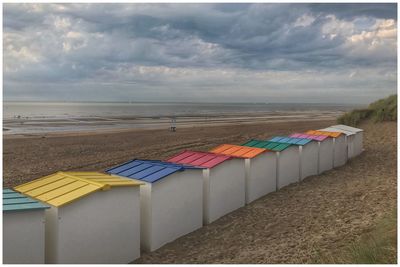 Multi colored umbrellas on beach against sky