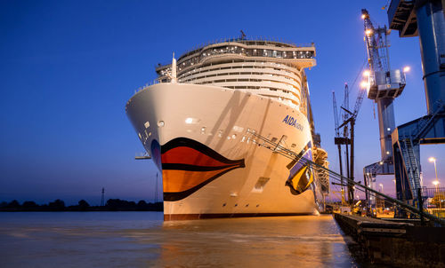 View of ship moored at harbor against blue sky