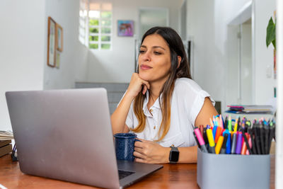 Young woman using mobile phone at home