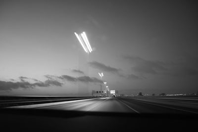 Illuminated road seen through car windshield at night