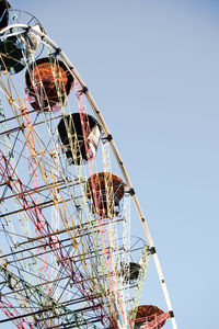 Low angle view of ferris wheel against clear blue sky