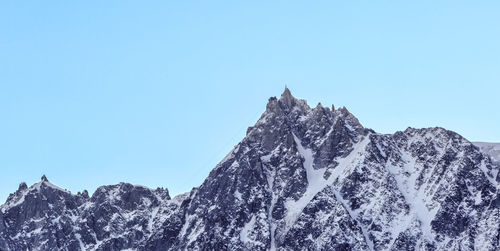 Low angle view of majestic mountains against clear blue sky