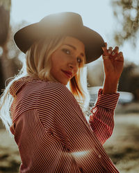 Portrait of young woman wearing hat during sunny day