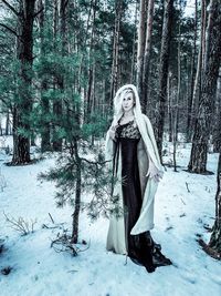 Portrait of female model standing in forest during winter