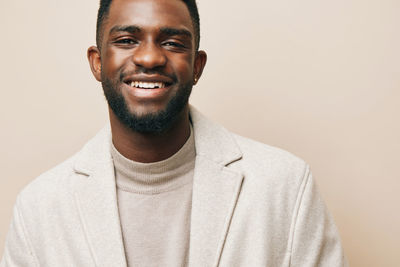 Portrait of young man standing against wall