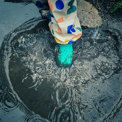 Low section of person standing in water