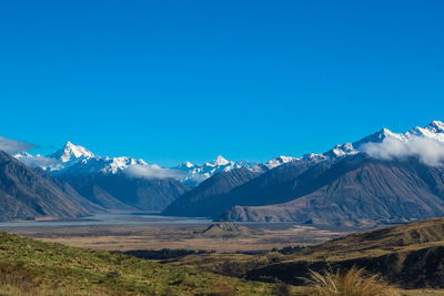 Scenic view of snowcapped mountains against blue sky