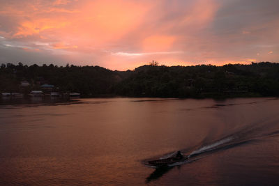 Scenic view of river against sky at sunset