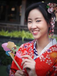 Portrait of young woman holding red flower