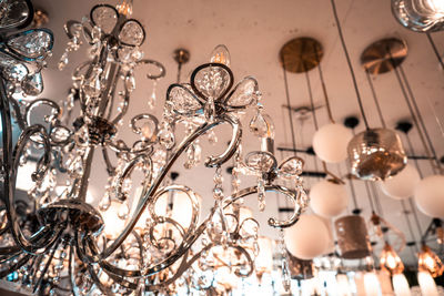 Low angle view of illuminated chandelier hanging on ceiling