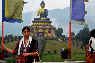 Woman standing at temple against building