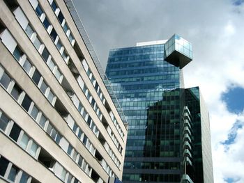 Low angle view of modern building against cloudy sky