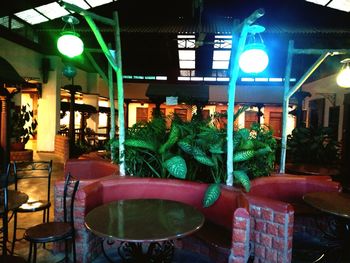 Empty chairs and tables in illuminated restaurant