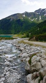 Scenic view of river by mountain against sky