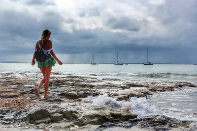 Rear view of woman looking at sea against sky