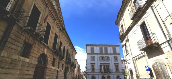 Low angle view of buildings against clear blue sky