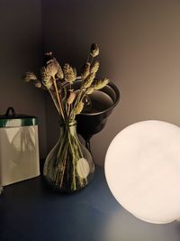 Close-up of vase on table against wall at home