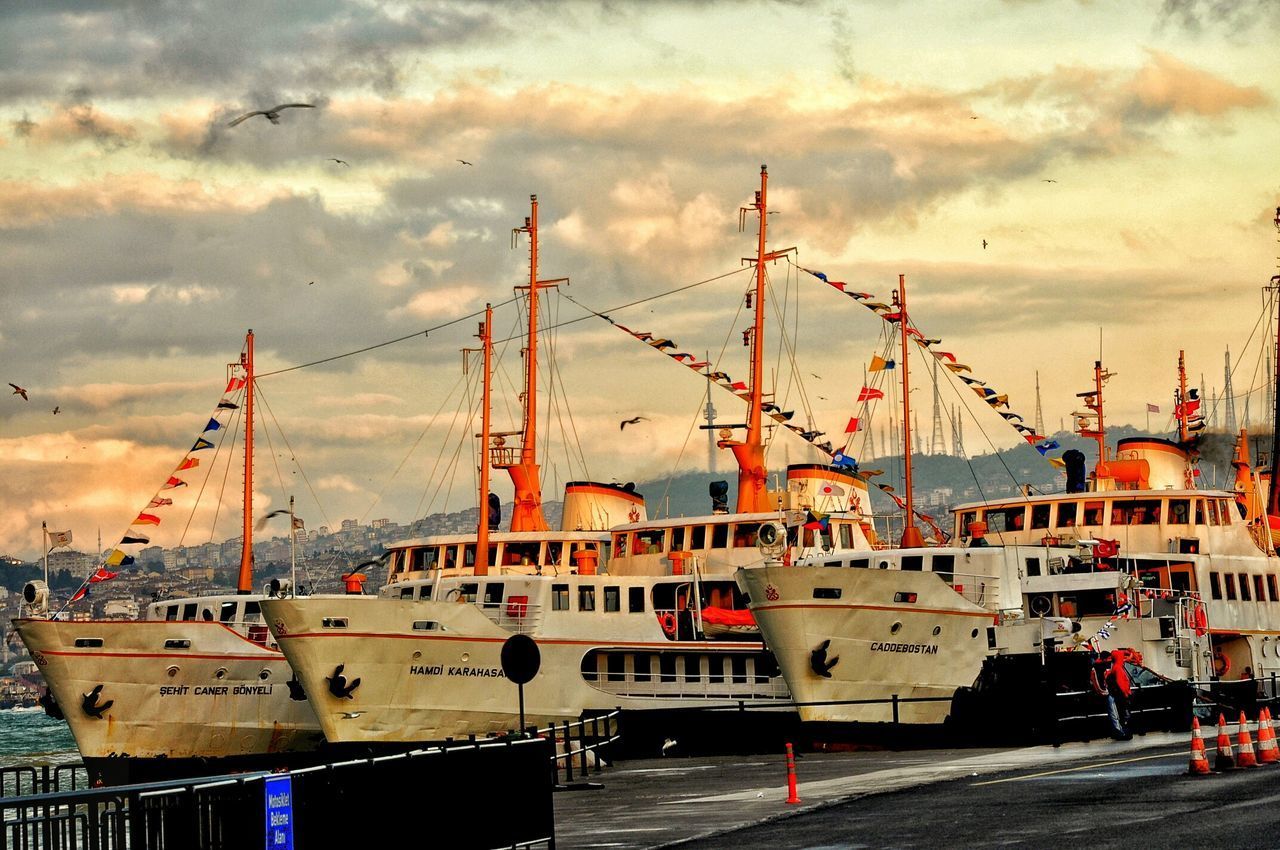 SAILBOATS MOORED AT HARBOR