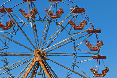 Low angle view of ferris wheel against clear blue sky