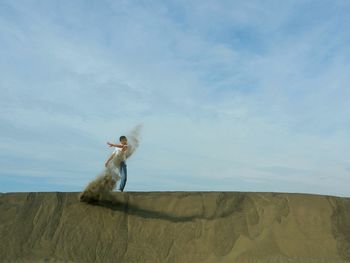 Man standing on desert against sky