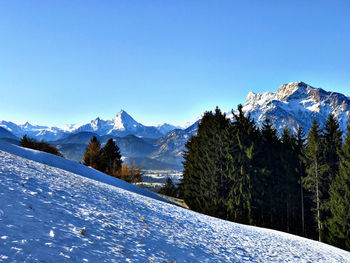 Scenic view of snowcapped mountains against clear blue sky