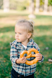 Portrait of cute baby boy standing on field