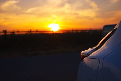 Close-up of car on road against sky during sunset