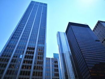 Low angle view of modern buildings against clear blue sky