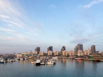 View of boats anchored at port with buildings in background