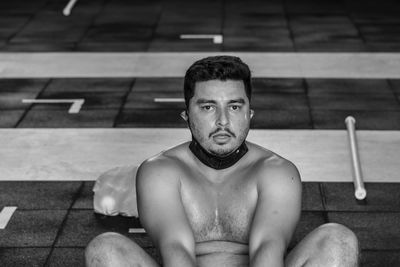 Portrait of young man sitting in swimming pool