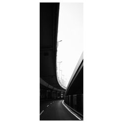 Bridge over road in city against clear sky