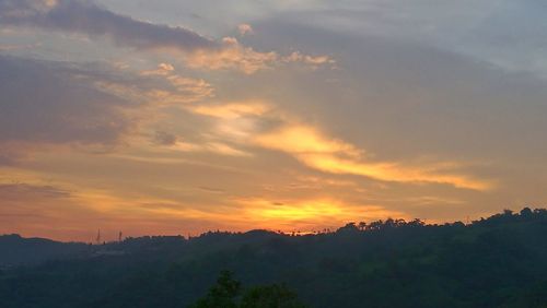 Scenic view of silhouette mountains against sky at sunset