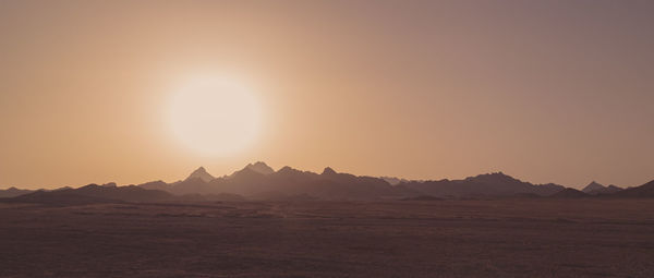 Scenic view of desert against sky during sunset