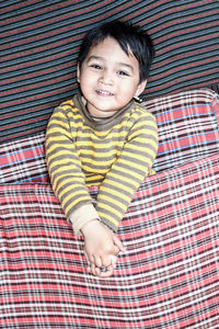 Portrait of smiling boy sleeping on bed