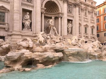 Statue of fountain in front of historic building