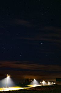 Light trails on street against sky at night