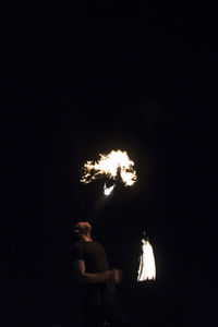 Silhouette of man with fire crackers at night