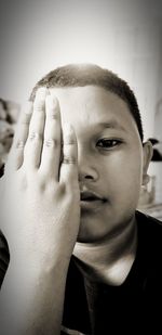 Close-up portrait of boy covering face