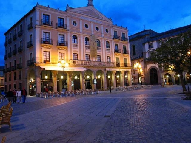 architecture, building exterior, built structure, illuminated, street, sky, city, night, street light, cobblestone, the way forward, facade, incidental people, road, building, outdoors, lighting equipment, empty, architectural column, travel destinations