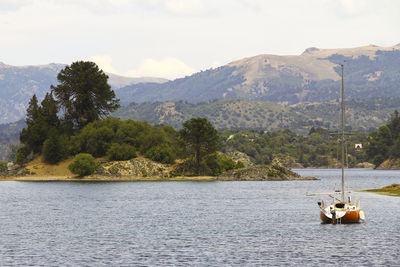 Scenic view of river and mountains against sky