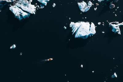 Full frame of boat navigating between icebergs 
